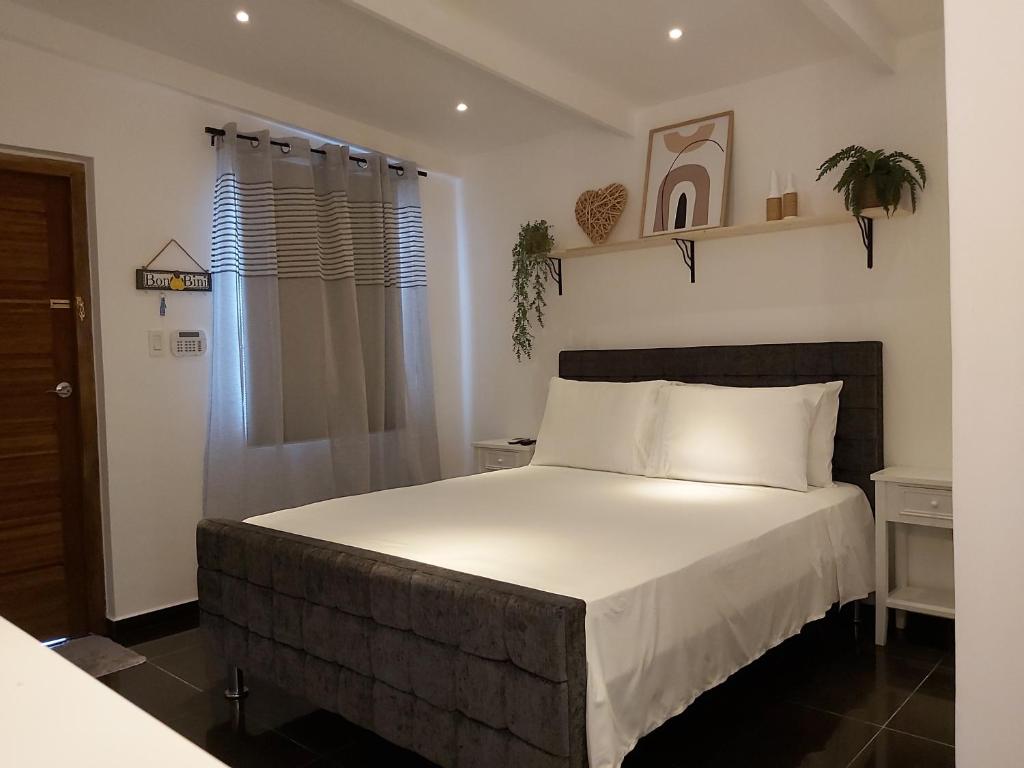 威廉斯塔德KDF公寓的一间卧室配有一张带白色床单的大床
