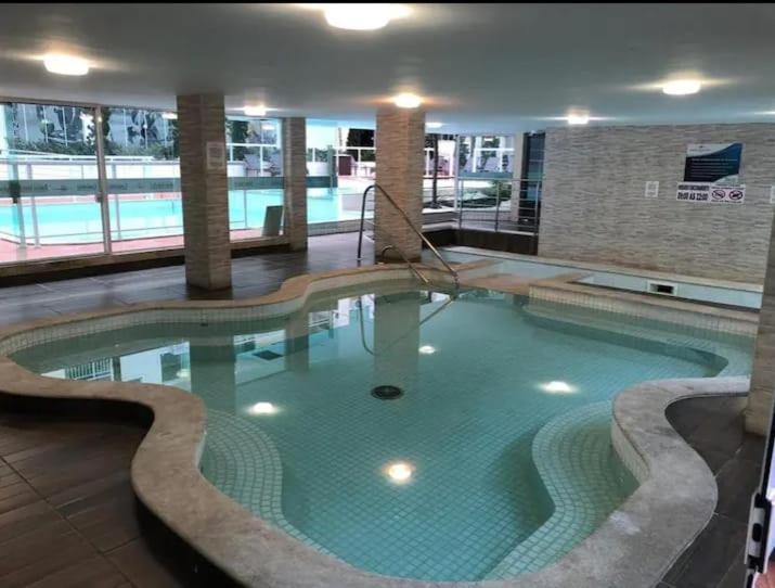 邦比尼亚斯Apartamento Maravilhoso,condominio com piscina aquecida coberta e mais 2 externas.的大型建筑中的大型游泳池