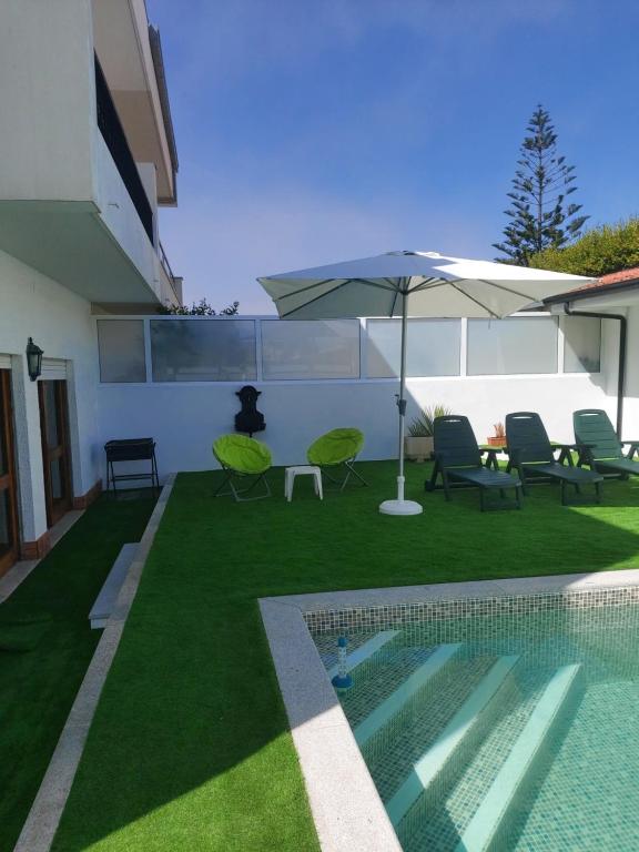 拉夫拉Lavra Beach House的后院设有游泳池、遮阳伞和椅子