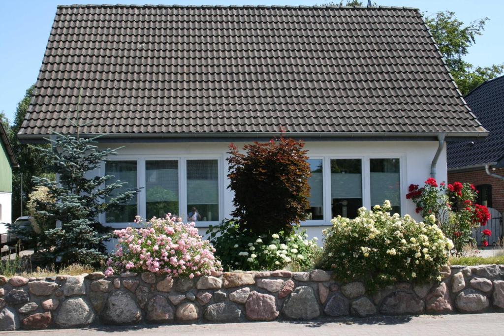 EggebekFerienhaus Frey的一座石墙和一些花卉的房子