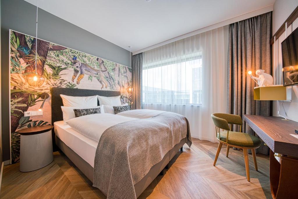 霍夫多普NinetyNine Amsterdam Airport的酒店客房设有一张大床和一张书桌。