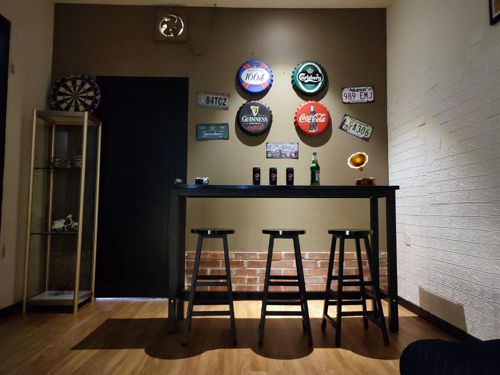 诗巫Kelly Homestay的墙上有凳子和标志的酒吧