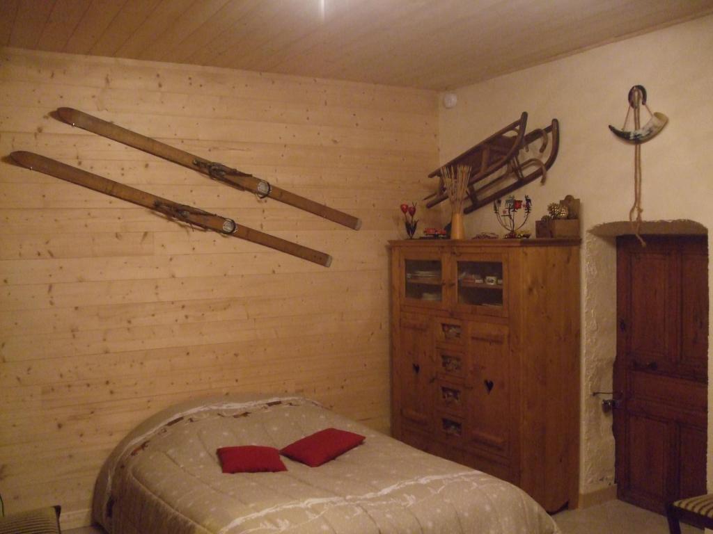 莫里永Chalet montagne 11 p Grand Massif 100 m télécabine的卧室配有一张床,墙上挂着棒球棒