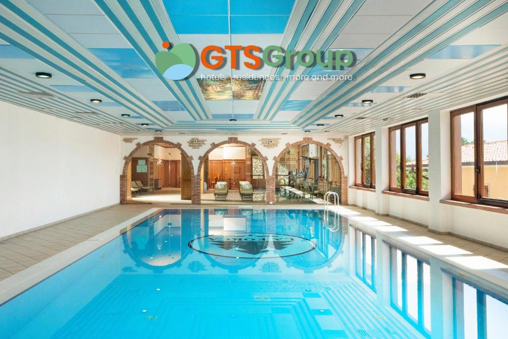 提尼亚类Hotel Residence Panorama La Forca, GTSGroup的大楼内一个蓝色的大型游泳池
