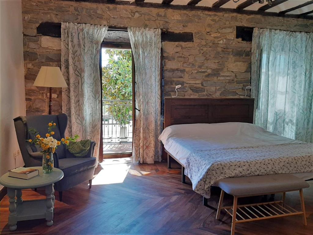 IzarraHotel Doña Lola的卧室配有床、椅子和窗户。