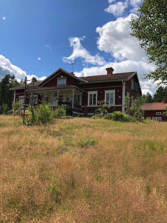 AlftaLånghedgården Bed & Breakfast的山丘上的房子,前面有田野