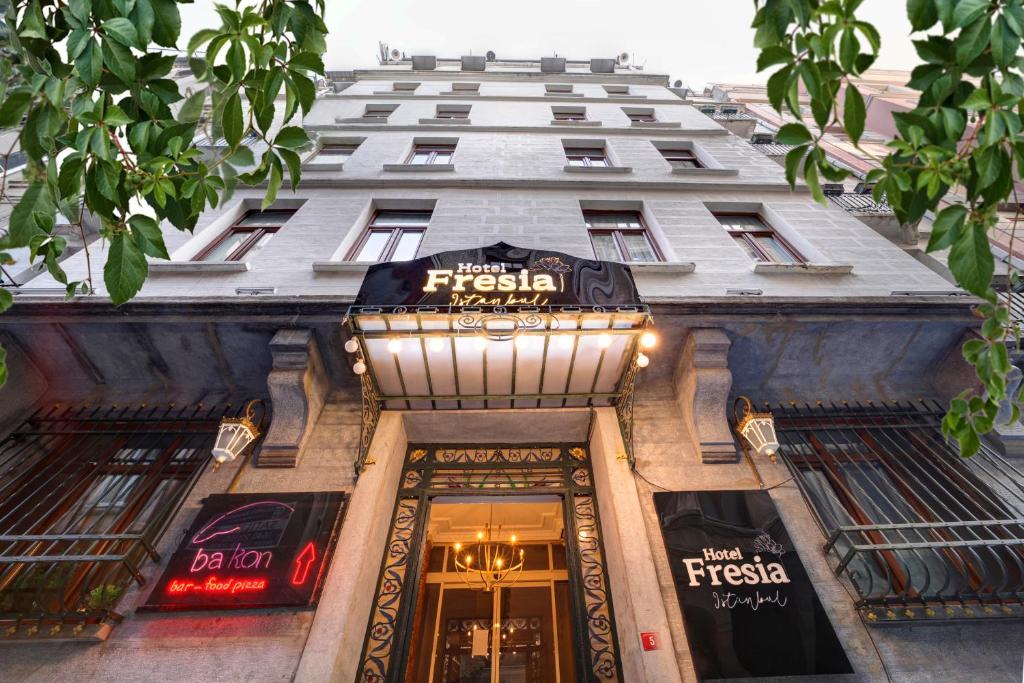 伊斯坦布尔Hotel Fresia Istanbul的商店入口上方标有标志的大建筑