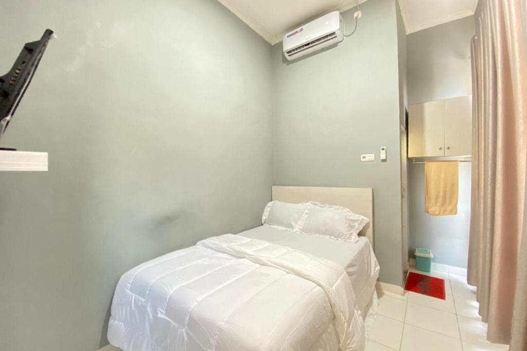 Talang KelapaPelangi Guest House Palembang RedPartner的一间白色卧室,卧室内配有一张床