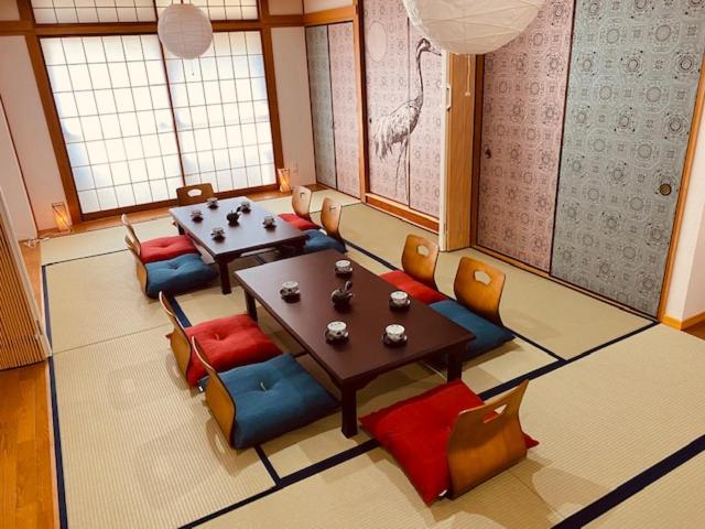 东京Ostay Numabukuro Hotel Apartment的一间配备有桌子和五颜六色椅子的用餐室