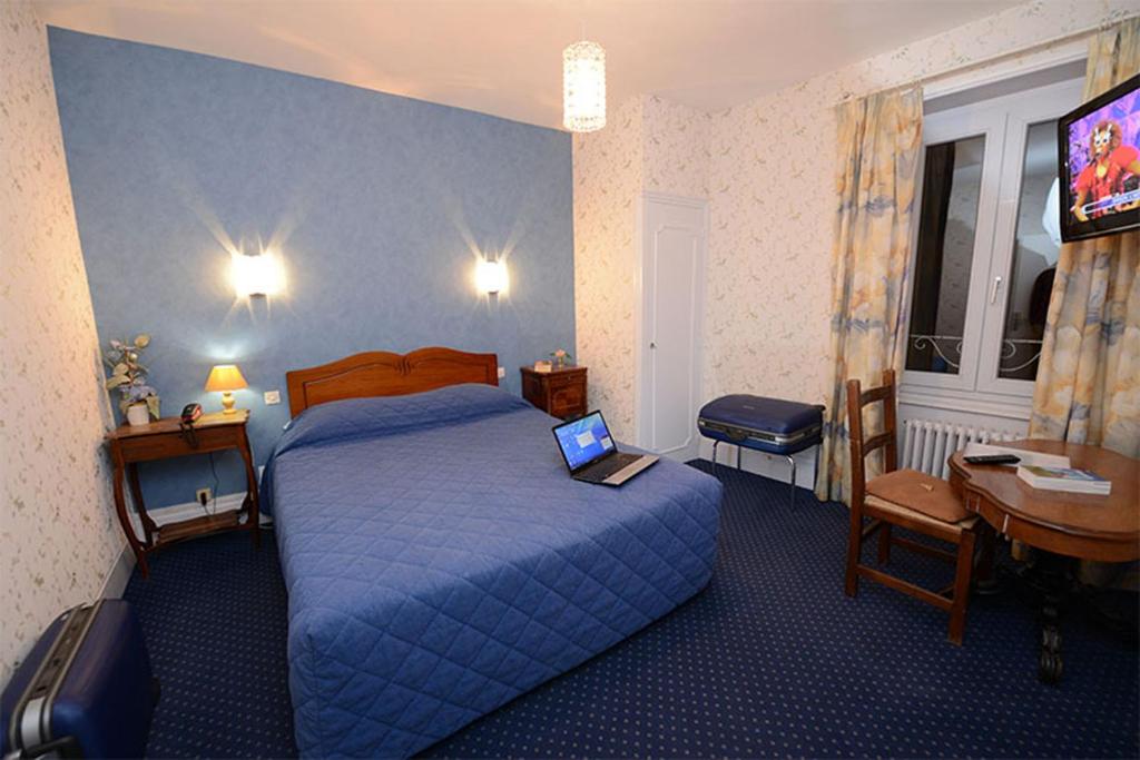 沙尼Hôtel De La Ferté的酒店客房,配有一张带笔记本电脑的床