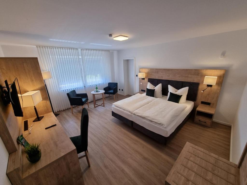 弗雷登Hotel Zum Jägerhaus的酒店客房带一张床、一张桌子和椅子