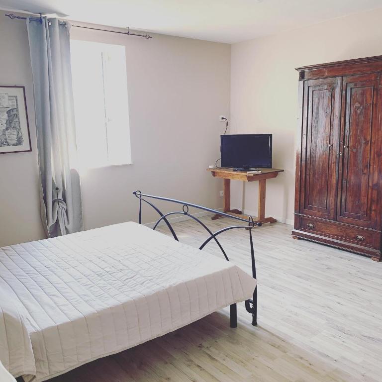 蒙蒂基亚里LA CHIUSA Bed and Breakfast的一间卧室配有一张床和一台电视。