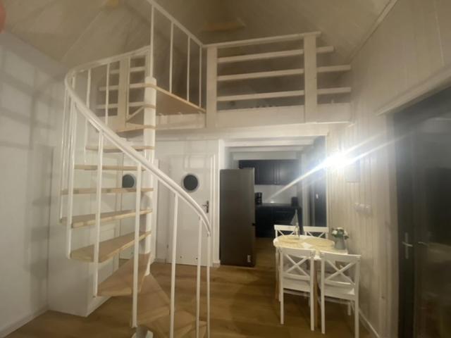 乌斯特卡Domek Morze的客房设有螺旋楼梯和书桌。