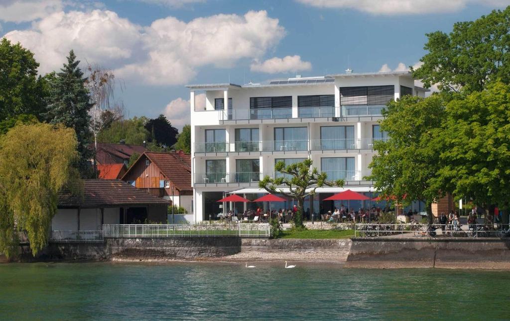 博登湖畔克雷斯波洛克利斯隆海景酒店的水体旁的白色大建筑
