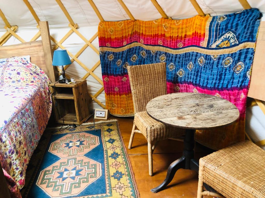 斯托尔河畔希普斯顿Cotswolds Camping at Holycombe的蒙古包内带一张床和一张桌子的房间