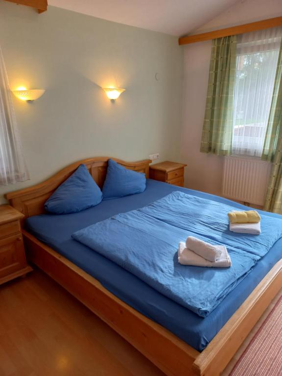 迈尔霍芬Bergsteiger Zimmer的一间卧室配有一张带蓝色床单和蓝色枕头的床。