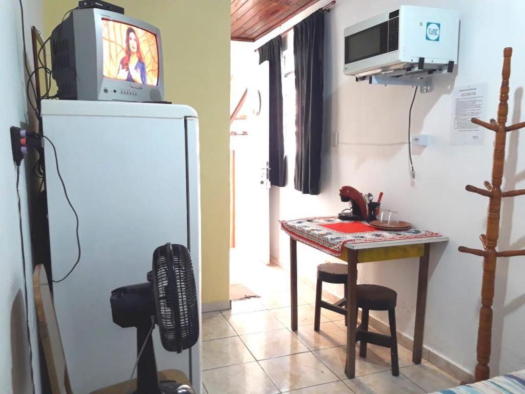 圣保罗Infinito Suíte的客房设有一张小桌子和一台冰箱内的电视