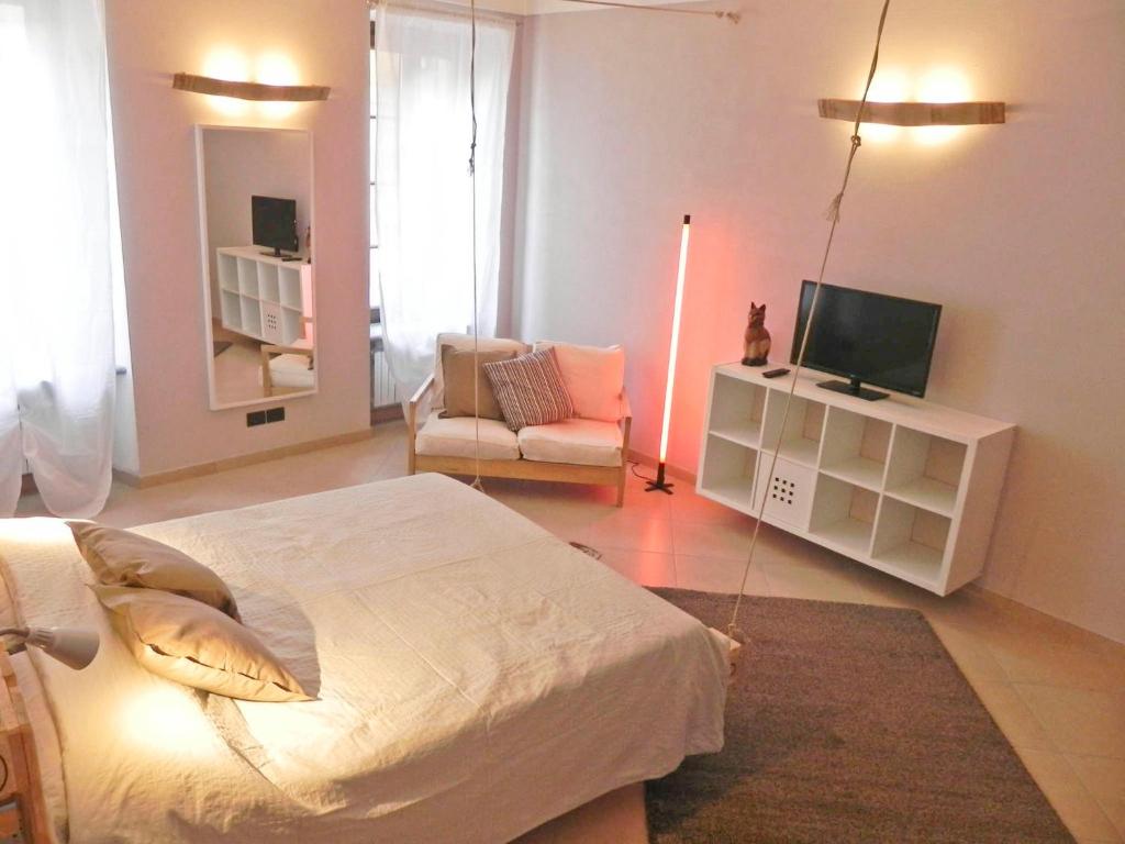 阿尔巴拉卡萨帝米莉公寓的一间卧室配有一张床、一台电视和一把椅子