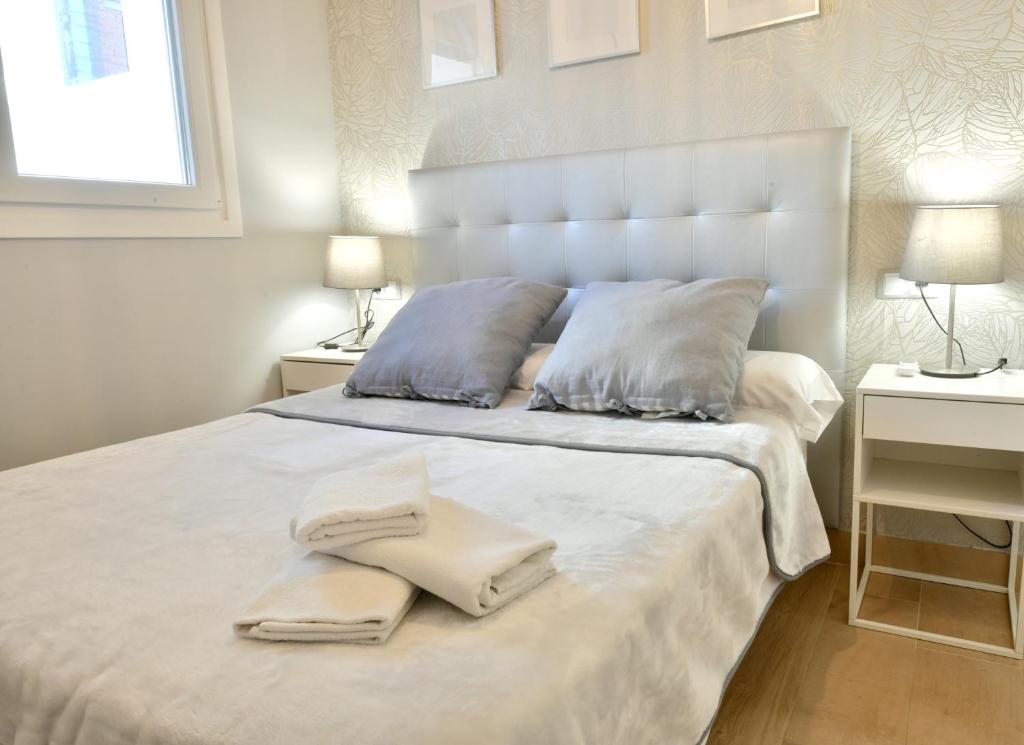 塞维利亚MS4 Apartamentos Nervión的卧室配有白色的床和2条毛巾