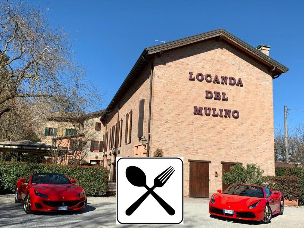 马拉内罗洛坎达德穆利诺酒店的两辆红色汽车停在大楼前
