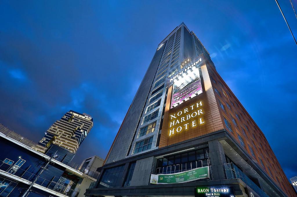 釜山Northharbor Hotel的一座高大的建筑,上面有标志