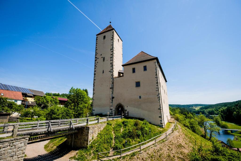 Trausnitz格特劳斯尼茨旅舍的一座有塔的建筑,位于一座有桥的山丘上