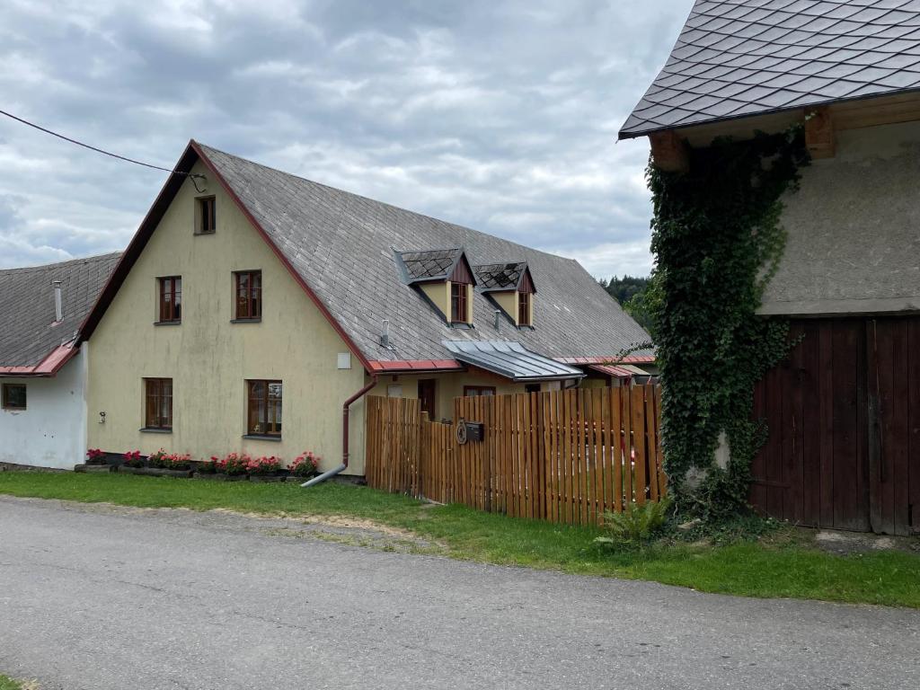 SněžnéUbytování Samotín的一栋白色房子,旁边是木栅栏