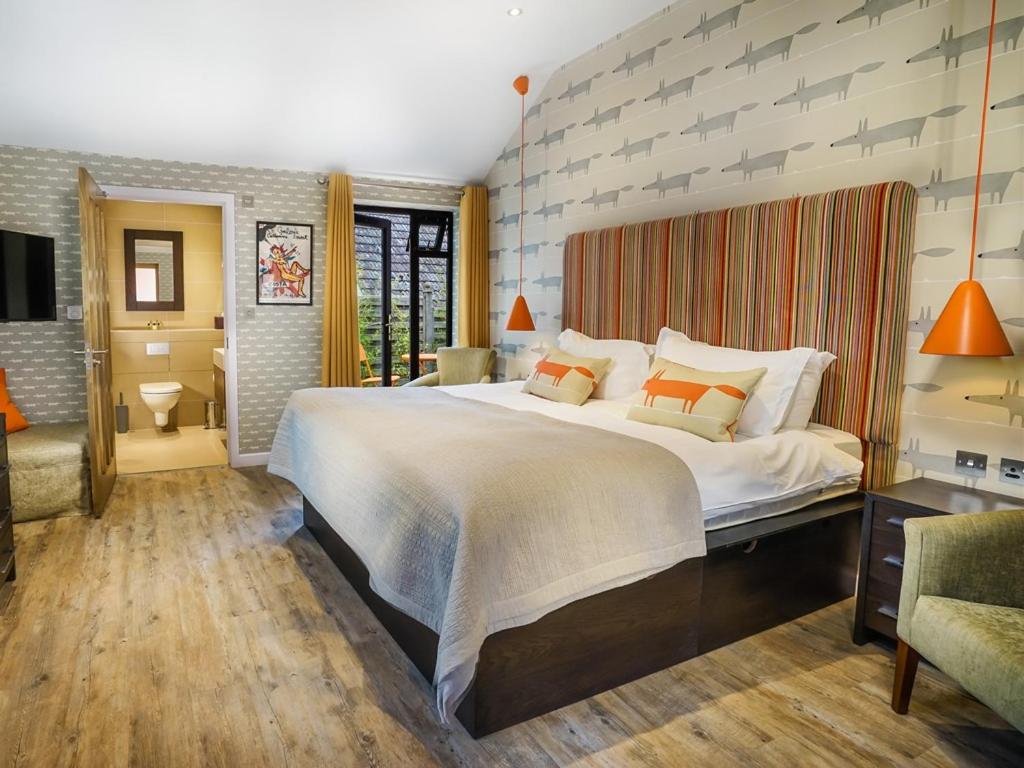 韦斯特勒姆面包店餐厅住宿加早餐旅馆的大卧室配有带橙色枕头的大型白色床