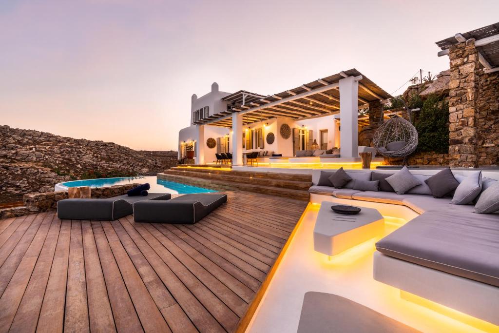 阿格拉瑞Villa Artisti Mykonos的一座带木甲板的房屋的后院