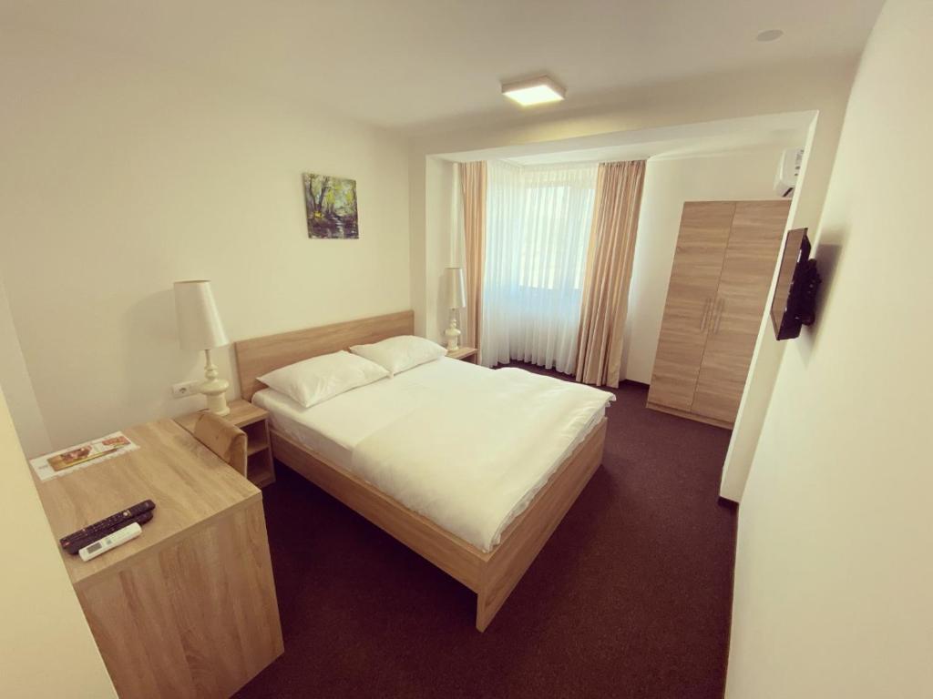 巴尼亚卢卡Hotel Tanja的酒店客房设有床、桌子和窗户。