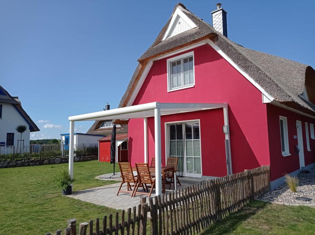 齐罗Dat Papenboerger Hus的红色的房子,配有椅子和甲板