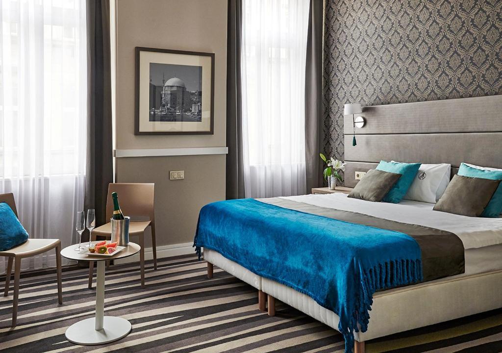 布达佩斯贝斯里卡中心酒店的酒店客房设有一张大床和一张桌子。