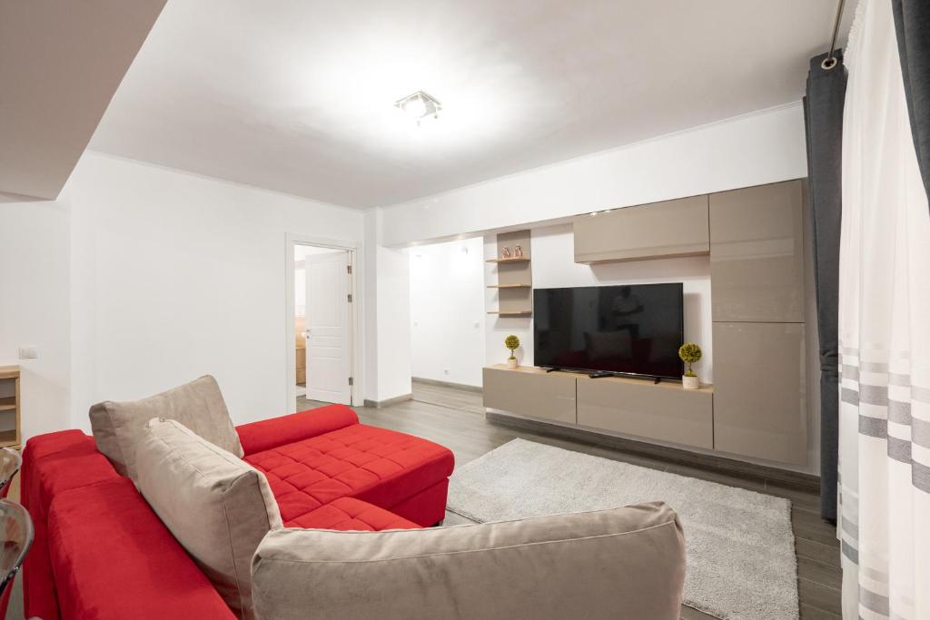 皮特什蒂Luxury Ultracentral的客厅配有红色沙发和电视