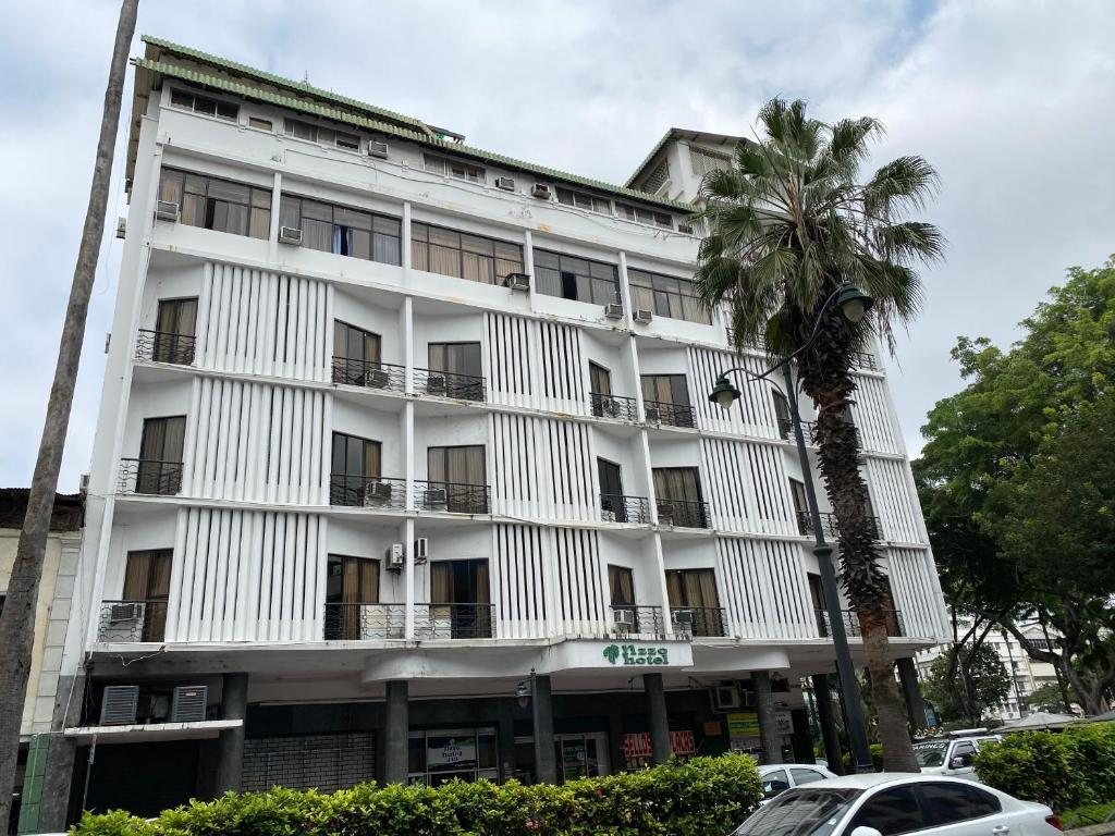 瓜亚基尔里佐酒店的一座白色的建筑,前面有棕榈树