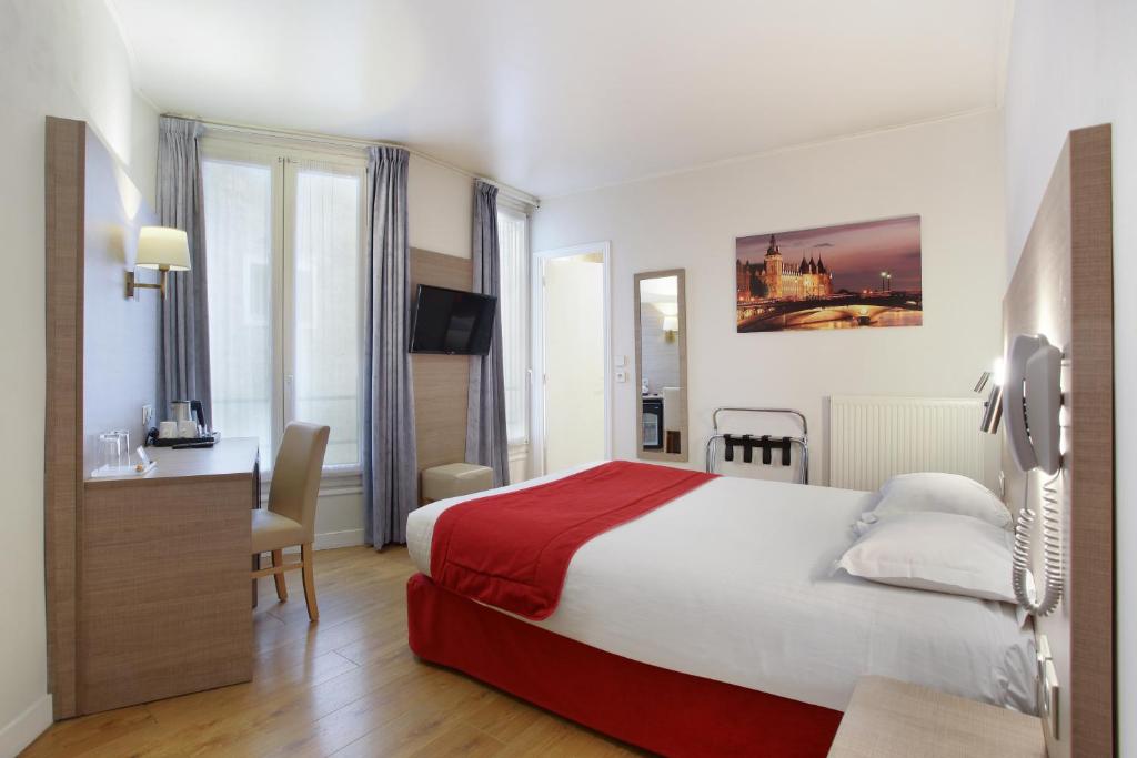 巴黎Hôtel LUX PICPUS的酒店客房设有一张大床和一张书桌。