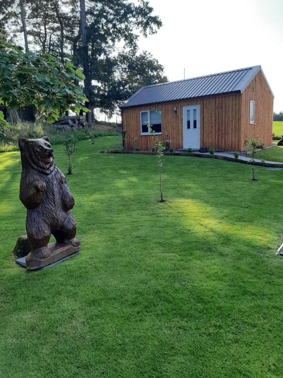 因弗内斯Beautiful studio chalet in the Highland的一座有建筑物的院子中熊的雕像