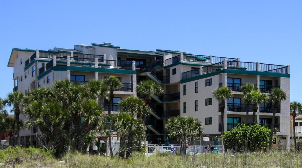 圣徒皮特海滩自由全季公寓式度假酒店的公寓大楼前方有棕榈树