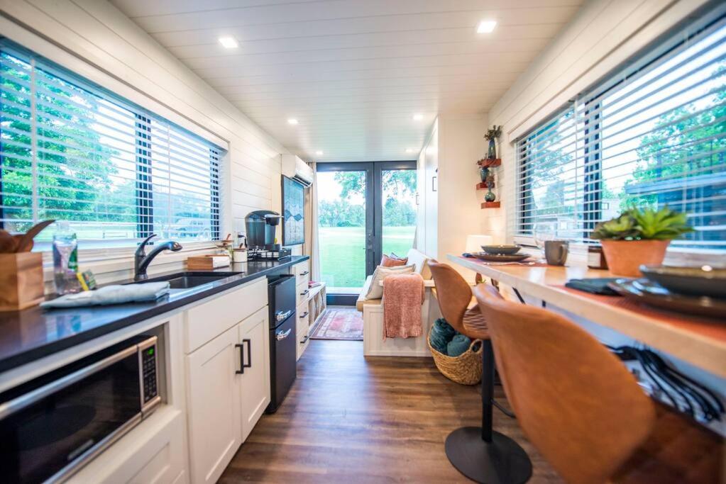 BellmeadNEW The Brazos-Tiny Home 12 Min to downtown的厨房配有水槽和带椅子的柜台。