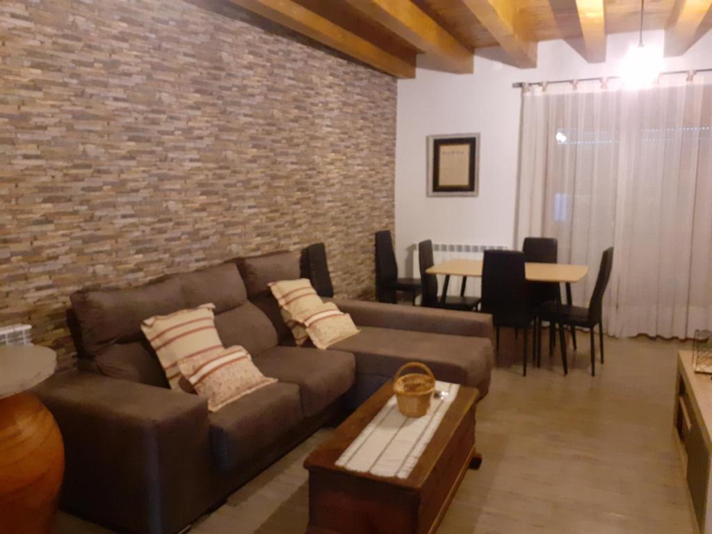 Olocau del ReyApartamentos CASA RURAL EL VENTANICO的带沙发和砖墙的客厅