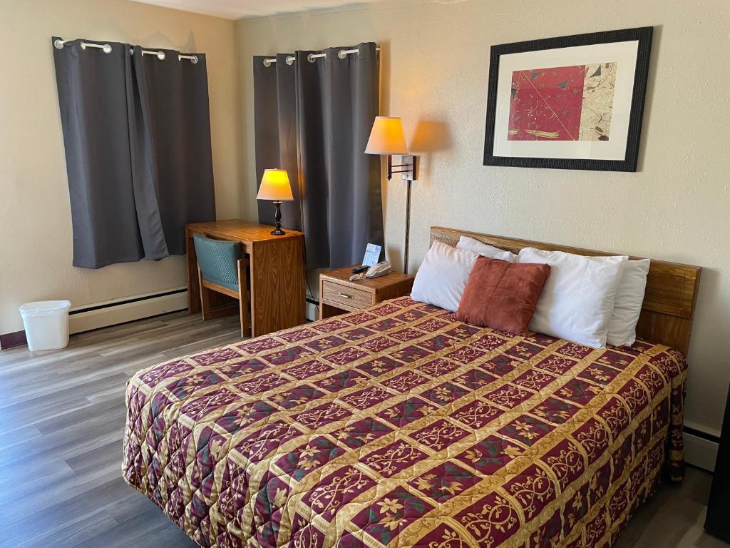 Fort MadisonRivers Inn的酒店客房配有一张床和一张带台灯的书桌