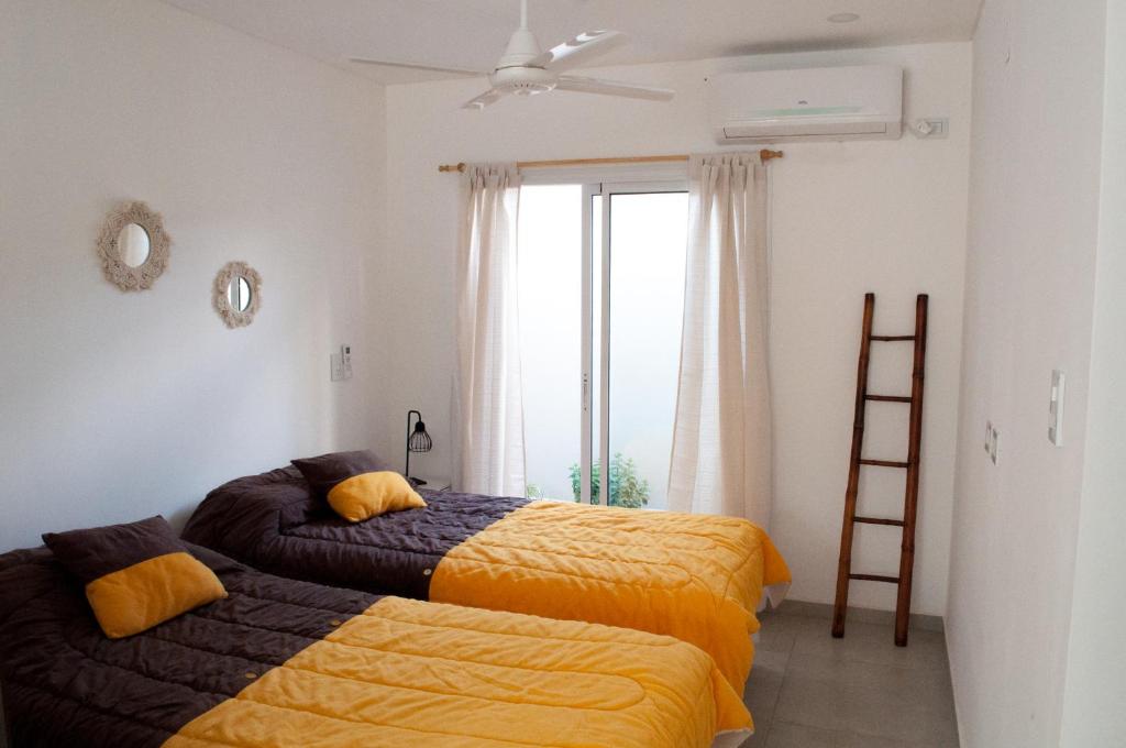 拉斐拉Mono ambiente amplio, luminoso y moderno con excelente ubicación的一间卧室设有两张床、梯子和窗户。