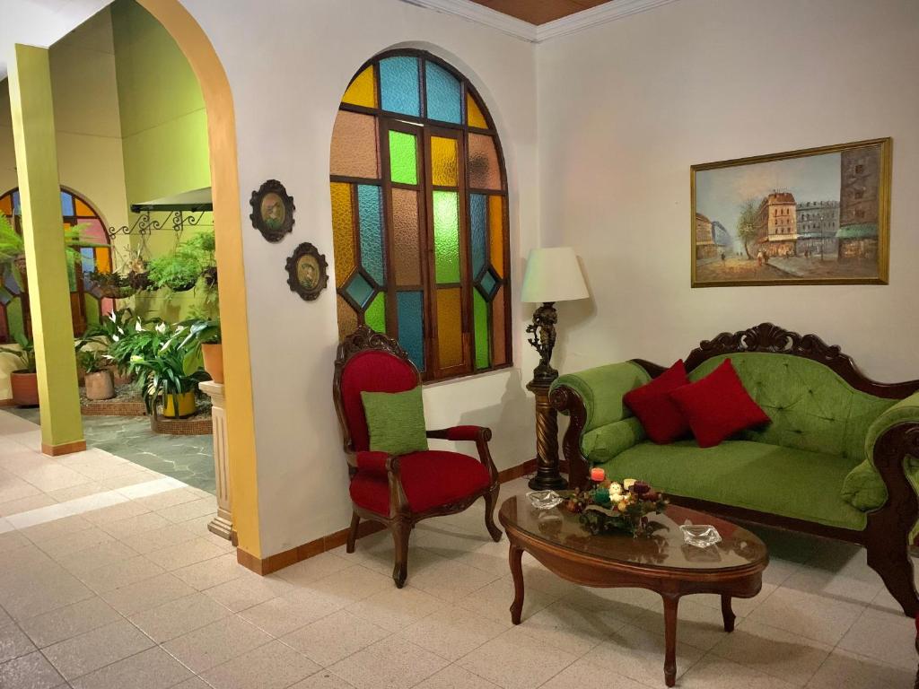 麦德林Casa Grande的客厅配有沙发、桌子和彩色玻璃