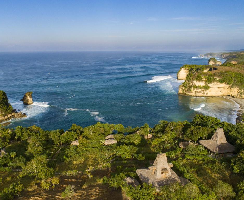怀卡布巴克Ngalung Kalla Retreat的享有海洋的岩石和树木的空中景致