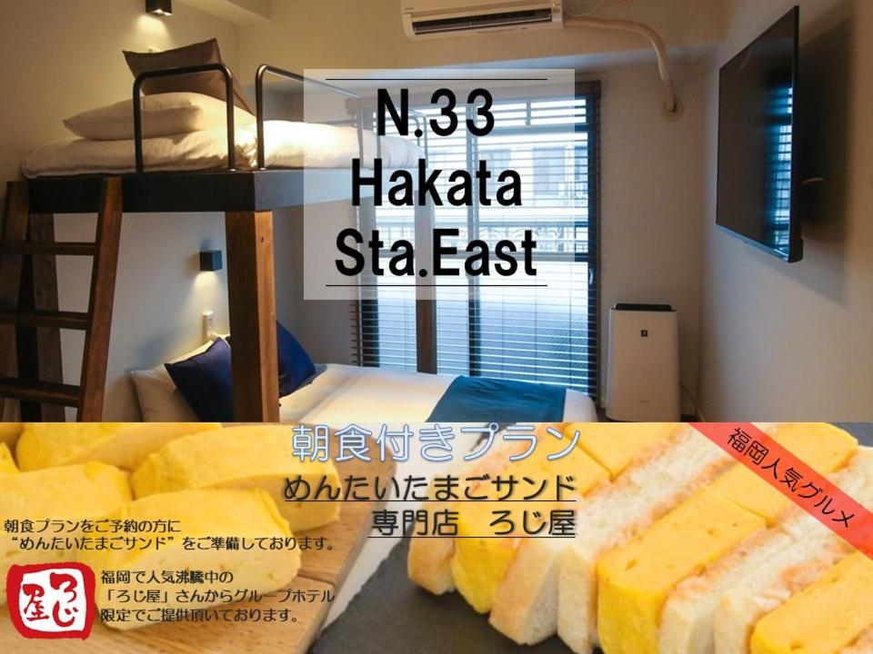 福冈N33 Hakata Sta East的宿舍间的一张海报,配有一张双层床