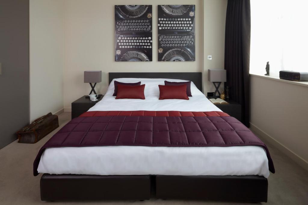 伦敦世外桃源酒店的一间卧室配有一张带红色枕头的大床