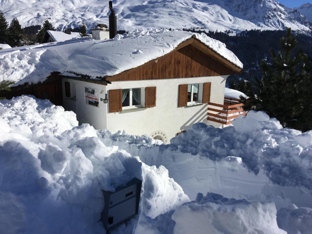 瓦尔贝拉Haus Tgamotsch***- Ferienwohnung in Valbella的雪覆盖的房子