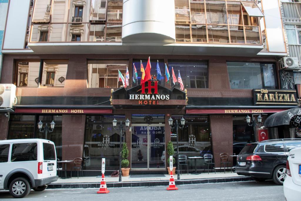 伊斯坦布尔Hermanos Hotel的一座有标志的建筑,上面有旗帜的餐厅