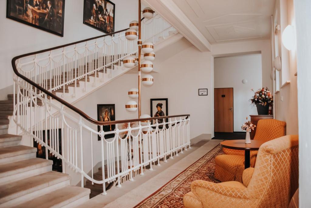 新伊钦B&B Hotel Praha的客厅的楼梯,配有两把椅子和一张桌子