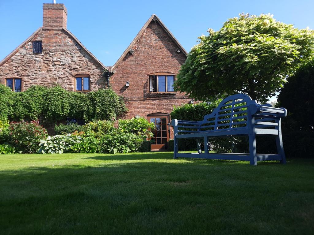 ArleyHood Lane Farm B&B的坐在房子前面的蓝色长椅