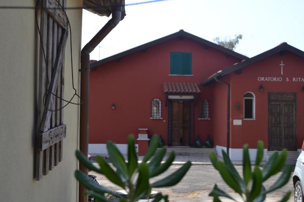 安齐奥Agriostello Riparo的前面有仙人掌的红色建筑